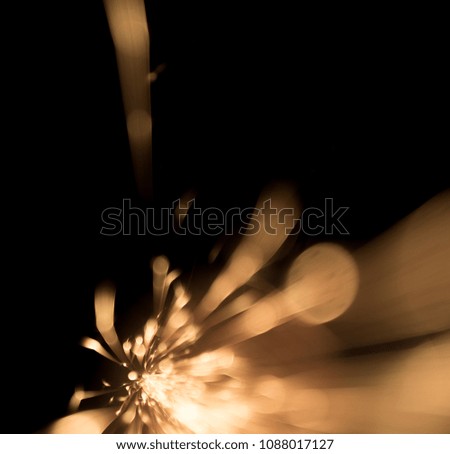 sparks from red-hot metal, bokeh warm tones, flashes in the dark