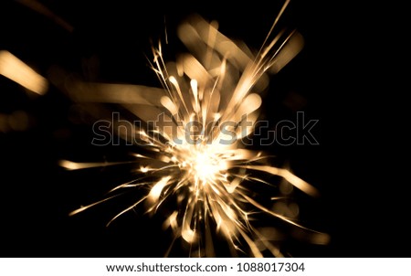 sparks from red-hot metal, bokeh warm tones, flashes in the dark