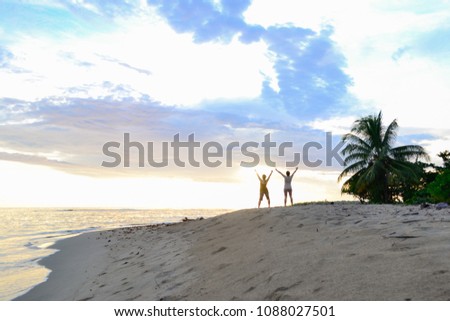 two women walking on the beach at dawn