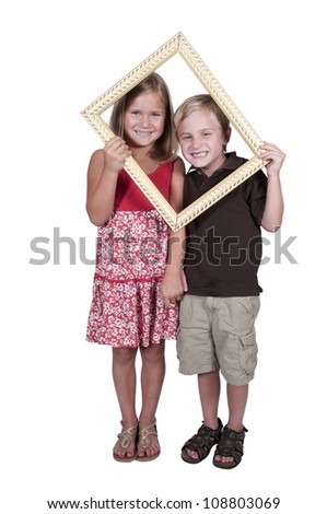 Little boy and girl looking through an ornate picture frame