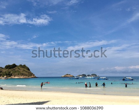 A beautiful landscape picture of beach and there was people and boats in the picture