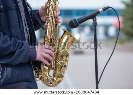 A man is playing on a saxophone