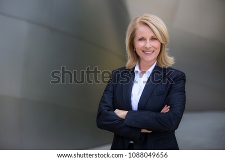 Confident and successful CEO business woman in a suit with arms folded Royalty-Free Stock Photo #1088049656
