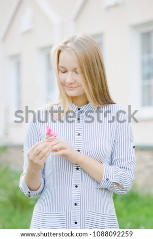 blond girl with bright flowers, florist, cares for flowering flower beds