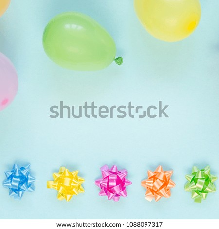 Colorfu festive decoration balloons and bows on blue background. Holiday, carnival or birthday party concept. Overhead shots. Flat lay. Copy space background