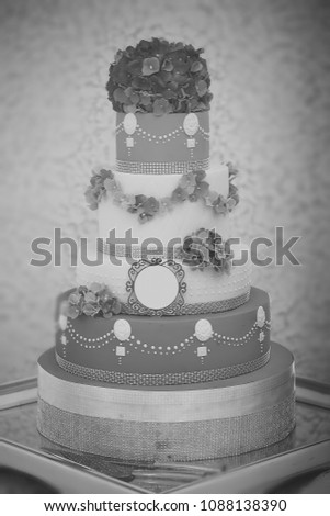 One large beautiful delicious many-tier decorated wedding cake white and blue colours with flower garlad and hydrangea bouquet on top, vertical picture