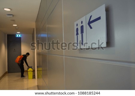 The toilet sign and a man who dumps a trash.