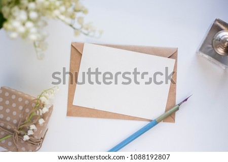  Workspace. Wedding invitation cards, craft envelopes, lilies of the valley