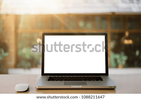 Workspace wooden desk on Laptop with blank screen and wireless mouse and graphics tablet and notebook,outdoor at home blurred background of light bokeh.