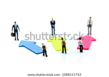 Miniature people: young Businessman standing in front of arrow pathway choice using as Business decision concept.