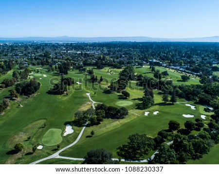 Aerial photograph of golf course and distant mountains.