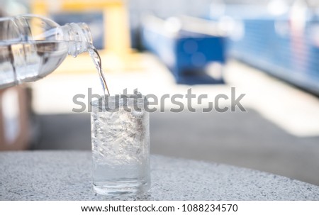 The water is in a clear bottle with a glass of ice. Water with Ice suitable for summer season.