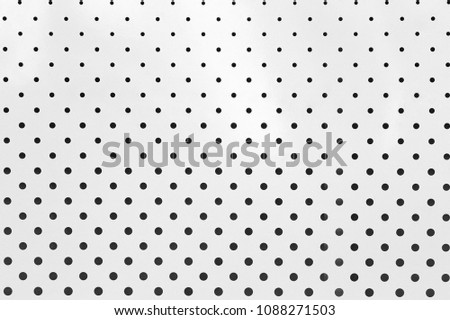 Background sheet of metal covered with lines of circular holes
