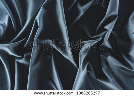 close up view of crumpled dark blue silk fabric as background