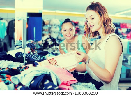 Two smiling young women shopping panties at the underwear shop