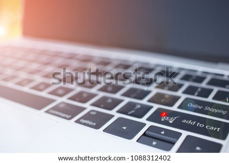 Online shopping concept, trolley icon and add to cart button on a computer keyboard. It allows consumers to directly buy goods or services from a seller over the Internet using a web browser.