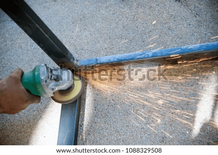 The worker is welding metal part of table steel in factory.