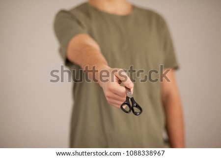 Man showing scissors in his hand