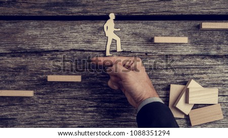 Businessman supporting paper cut out of a man climbing stairs, toned retro effect. Royalty-Free Stock Photo #1088351294