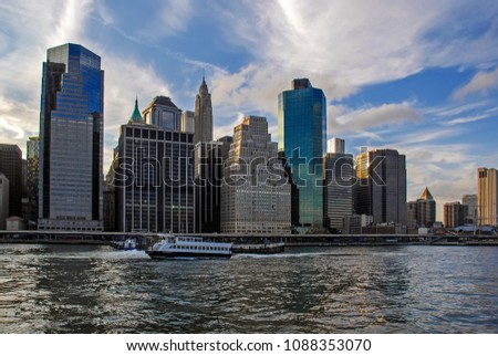 Beautiful view of Manhattan with tourist ship on East River against the fantastic sunset sky in New York City, USA
