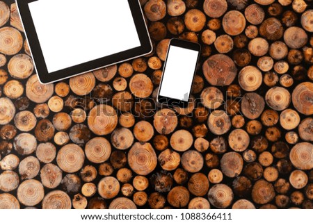 Digital tablet pc and mobile phone on wood background.Felled wood. Wood texture