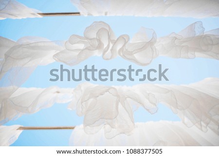 White cloths hang on the steel pipe with blue sky background.