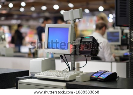 Rows of cash desks with cashiers and customers on blurry background