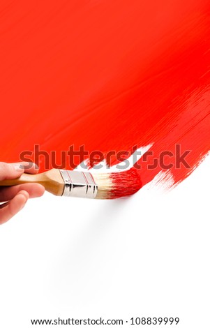 Painting with red colored ink and paintbrush on white