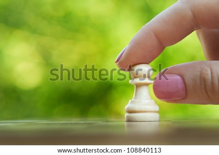 woman playing chess and hold pawn background