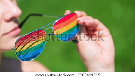 Hand holding rainbow glasses. Summer concept