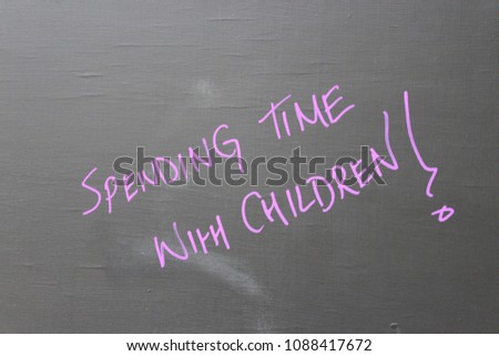 'Spending Time With Children!' chalk message on a blackboard