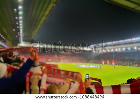 Blurred background of football players playing and soccer fans in match day on beautiful green field with sport light at the stadium.Sports,Athlete,People Concept.Anfield,Liverpool.UK Royalty-Free Stock Photo #1088448494