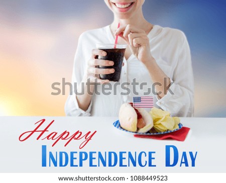american independence day, celebration, patriotism and holidays concept - close up of happy woman with hot dog and chips drinking cola from plastic cup at 4th july party over evening sky background