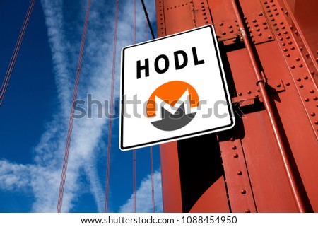 Cryptocurrency "HODL" concept, Monero XMR crypto logo on a traffic board sign, on golden gate bridge, with bright blue sky in background, bear market long time hold and not sell visualization 
