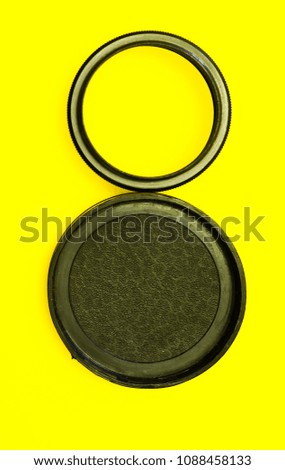 Ring for macro shooting and lens cap in the form of a figure eight on a yellow background