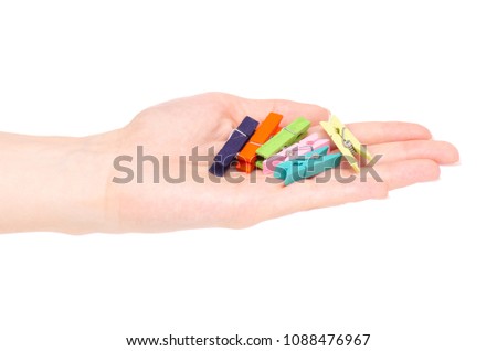 The colorful stationery clothespins in hand on white background isolation
