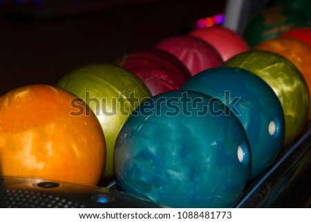Multicolored bowling balls of different weight ready for the game