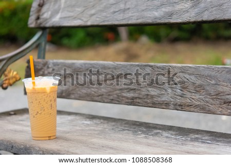 Coffee cool moment the sun is low. On a wooden chair in the park