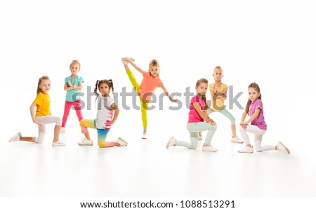 The kids dance school, ballet, hiphop, street, funky and modern dancers on white studio background. Girl is showing aerobic and dance element. Teen in hip hop style