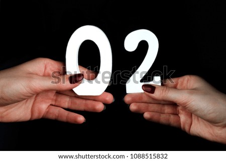 On a black background, female hand with number zero and two.