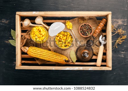 Pickled corn in a jar. Stocks of food. Top view. On a wooden background. Copy space