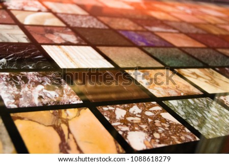 Background in the form of a surface of tiles of different colors of marble. Ancient slices of stones. Vintage tiles