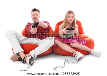 Teenage girl and her father playing video game on white background