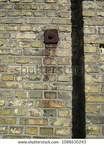 Detail of yellow brick wall with rusty wall anchors