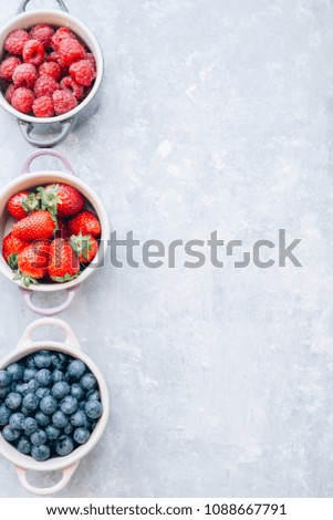 Summer fruit background, top view of berries , smoothie ingredient, inside ceramic colored cocotte, blueberries, strawberries, raspberries, flat lay