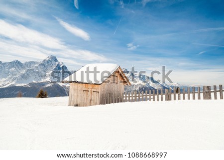 Little cottage covered with snow in the high Dolomites Alps mountains, winter landscape. Mont'Elmo, San Candido, Italy Royalty-Free Stock Photo #1088668997