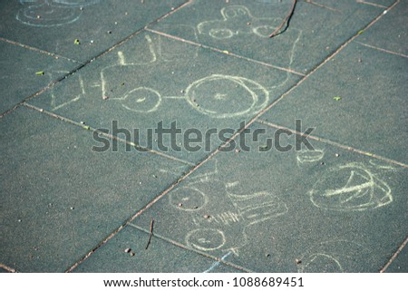 Children's simple drawing on the asphalt chalk. A child painted car chalk on the ground. Chalked dreams of a car.