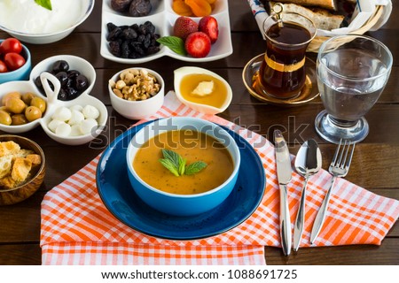 Traditional Turkish Ramadan-iftar dinner table with Turkish soup, Ezo Gelin in blue color soup set on wooden table.