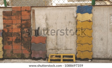 Pile of Colorful Bricks by Vintage Old Wall with Barbed Wire Fence