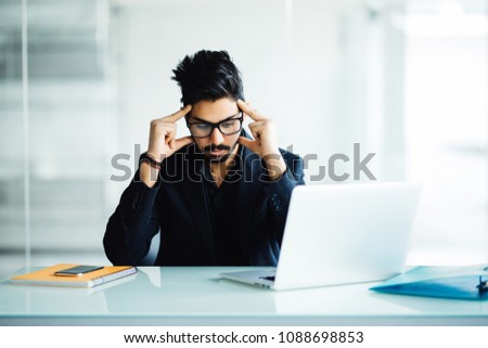 Closeup portrait of a busy guy in deep thought while looking at his laptop, studying serious, isolated on a city and nature background in his home or office